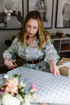 Woman wrapping present in creative studio