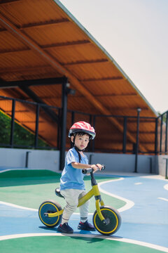 Child riding balance bike urban playground photography sunny day close-up fun