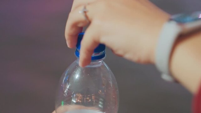Closeup plastic bottle cap resting on bottle neck, soft bokeh lights, subtle condensation, empty water interior, calm nighttime mood, minimalist composition, product detail shot, gentle reflections
