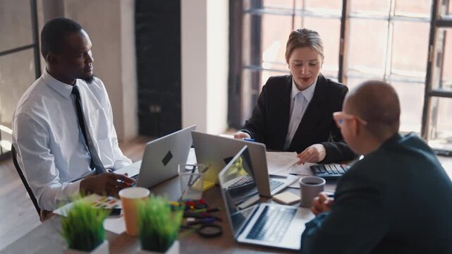 Conference with colleagues or partners in office, business meeting, diversity. Teamwork and brainstorming in marketing department, people sitting at table and discussing ideas and financial reports