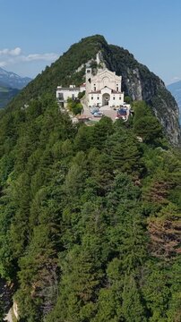 Wide-angle aerial shot of the Montecastello religious complex in Tignale, an iconic landmark of Brescia.