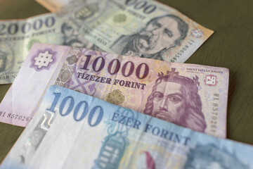 Fototapeta premium Hungarian banknotes in denominations of 1000 and 10000 forints. Distinctive designs feature historical figures and national symbols. Colors range from pale blue to soft purple and off-white