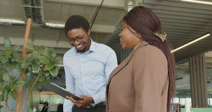 Seated male coworker offers pleasant remarks alongside plants and gadgets