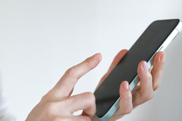 スマートフォンの画面を操作する手 © webbiz