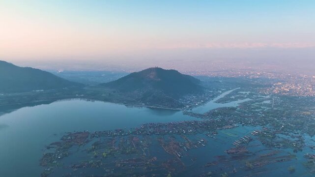 Aerial sweep of Dal Lake floating gardens and Srinagar cityscape.