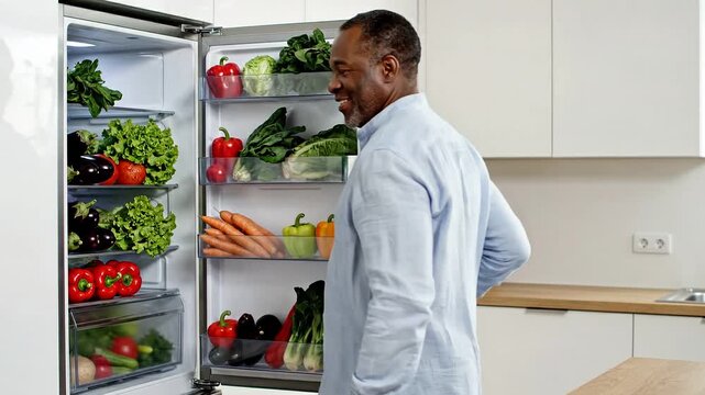 Person filling fridge with fresh vegetables