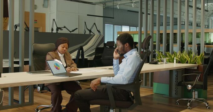 Team members strategize with laptops and visual charts together
