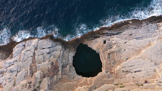 Flying above epic seaside natural rocky pool. Giola lagoon, Thassos island, Greece, aerial slow motion view