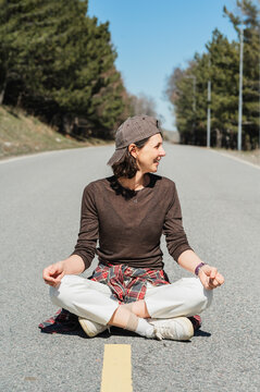 Woman meditating on an empty mountain road in nature