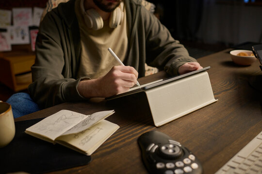 Freelancer drawing on graphics tablet at desk indoors