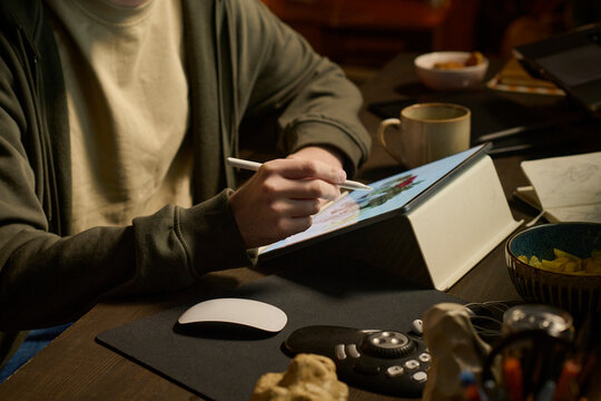 Unrecognizable designer drawing on graphics tablet at home office