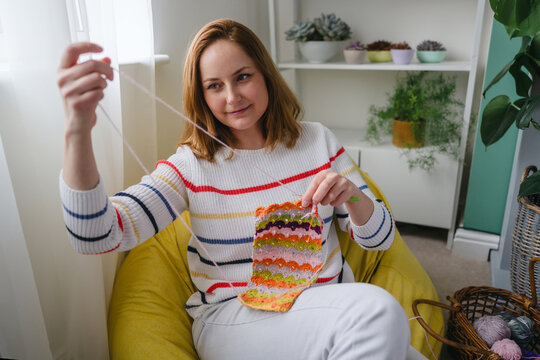 Woman crocheting colorful yarn at home