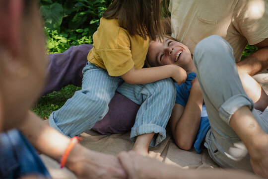 Family bonding and playful tickling in summer garden at home
