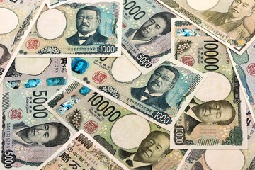 Japanese yen money banknotes pile on table. Japan bills of JPY currency. Concept of economy © Larysa