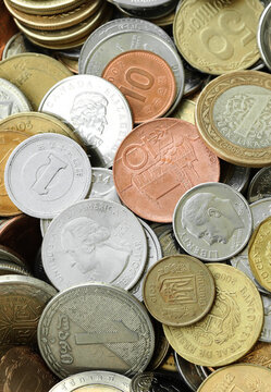 Scattered coins of multiple origins in big mound, detailed shot. World currency variety
