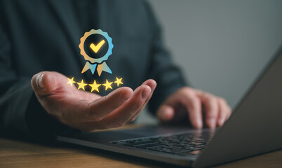 Naklejka premium Businessman presenting quality assurance badge with five star rating and approval check mark above laptop, customer satisfaction, service excellence, trust, feedback and online review concept