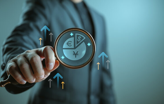 Businessman analyzing global financial data through magnifying glass with currency symbols, growth arrows, representing investment strategy, market analysis, financial growth in international economy