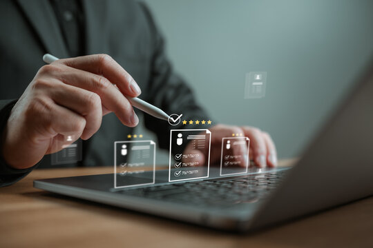 Businessman using laptop to select best candidate resume with star rating. Concept of human resources management, online recruitment, digital hiring process, and talent acquisition technology.