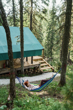 Serene camper resting in a hammock near Siberia glamping tent