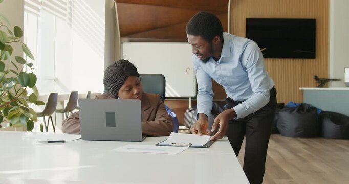 Finance manager discusses spreadsheets in office setting