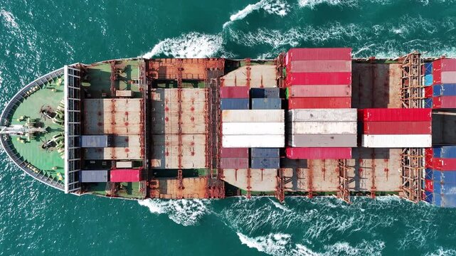 large cargo container ship fully loaded with colorful containers sailing through the deep blue ocean. Global maritime trade, freight transport and logistics business.	
