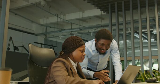 Leaders and team members urgently fixing laptop problem together