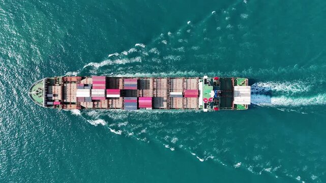 large cargo container ship fully loaded with colorful containers sailing through the deep blue ocean. Global maritime trade, freight transport and logistics business.	
