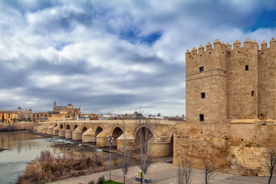 Calahorra Tower and Roman Bridge in Cordoba, Spain. Ancient stone fortress architecture, soft cloudy sky, no people