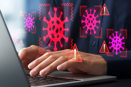 Computer virus infection and security software identifying malware. Businessman using laptop computer infected with ransomware.