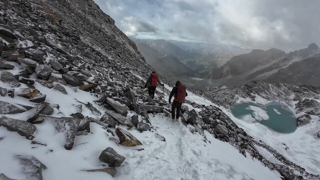 POV hiking on snow with other mountaineers and panorama view of Aosta Valley mountains in summer in Pennine Alps, Italy