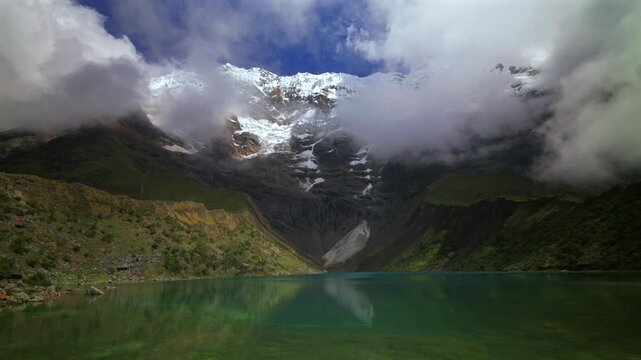 Turquoise clear glacial water Peru's Laguna HumantayLake Humantay rocky shoreline Peruvian Andes Mount Humantay Peru nature landscape view snow covered peaks fog cloud layer morning sunny cloudy pan