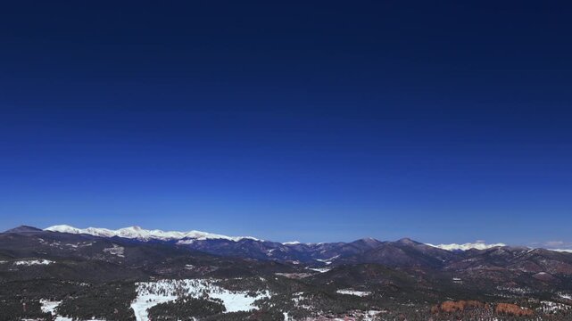 Vast Blue Sky Mountain Snow-covered Peaks landscape Evergreen Mount Blue Sky Front Range Rocky Mountains Colorado aerial drone spring snowy trees dense forest sunny morning Mt Evans Wilderness forward