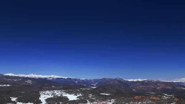 Blue Sky Mountain Snow-covered Peaks vast hillls landscape Evergreen Mount Blue Sky Front Range Rocky Mountains Colorado aerial drone spring snowy trees dense forest sunny morning Mt Evans forward