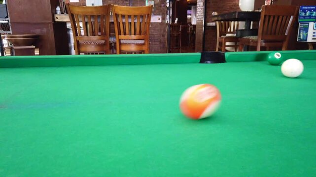 Close-up footage of the white ball being potted, a pool shot with billiard balls. The clip captures the deciding moment of a billiards game, making it ideal for sports content, bar games scenes