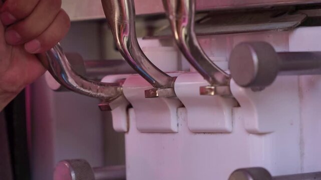 Soft serve ice cream flowing from machine into plastic cup, close-up detail, dessert making process, frozen treat, food industry equipment.