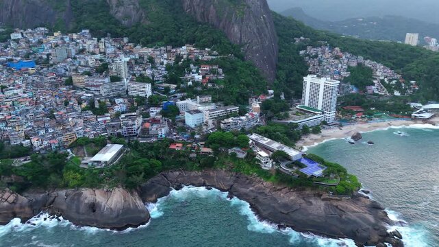 Vidigal and Praia do Vidigal Rio de Janeiro Brazil between Leblon and Sao Conrado with Sheraton Grand Rio Hotel Resort at base of Morro Dois Irm&atilde;os and favela slum near atlantic coast, drone sliding