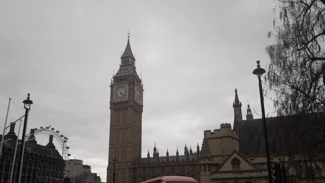 London's big ben clock tower and parliament with a red bus passing on an overcast day, featuring the famous london eye ferris wheel and iconic city architecture
