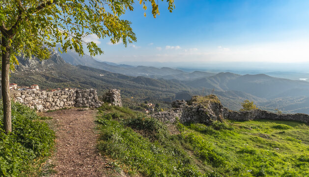 Rural countryside Albania. Mountain range with small village in the valley with sunset vibrant sky