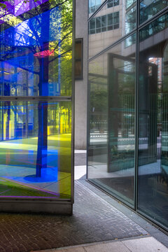 Colorful abstract urban architecture with glass facade reflections and windows near entrance showing modern design and city light in panels