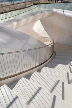 Modern minimal abstract staircase with spiral curve concrete steps and shadows showing clean architecture form in a quiet modern space