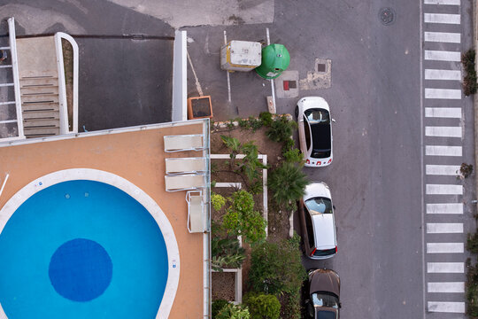Minimal modern abstract aerial urban geometry pattern showing pool swimming beside street crosswalk with cars and parking from above