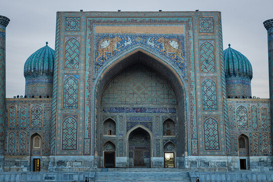 Sher-Dor Madrasa facade at Registan Square in Samarkand with turquoise tilework and domes. Ideal for travel publications, heritage content, and cultural brochures about Uzbekistan.