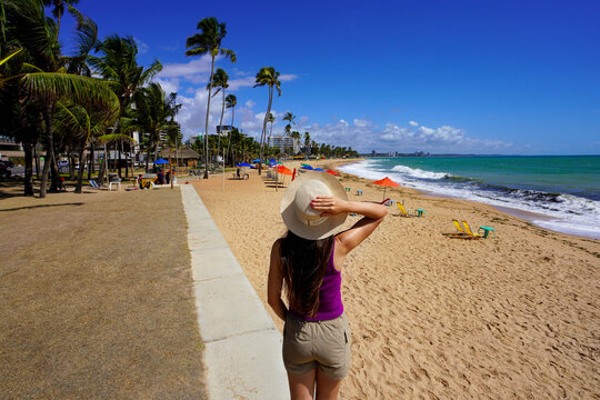 Vacation in Brazil. Back view of traveler woman looking at amazing beach in Maceio, Brazil.