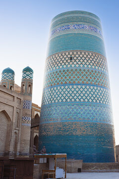 Kalta Minor minaret with turquoise tile patterns in Ichan Kala old town of Khiva, Uzbekistan. Ideal for travel guides, cultural publications, and tourism marketing materials.