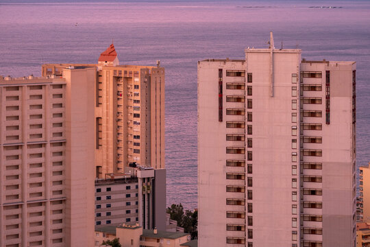 Quiet sea coastline frames city architecture where highrise towers shape the skyline of Benidorm near Alicante Spain