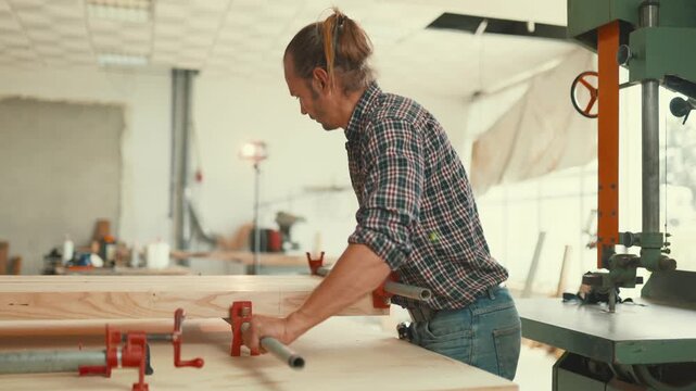 Professional carpenter clamping wood planks together