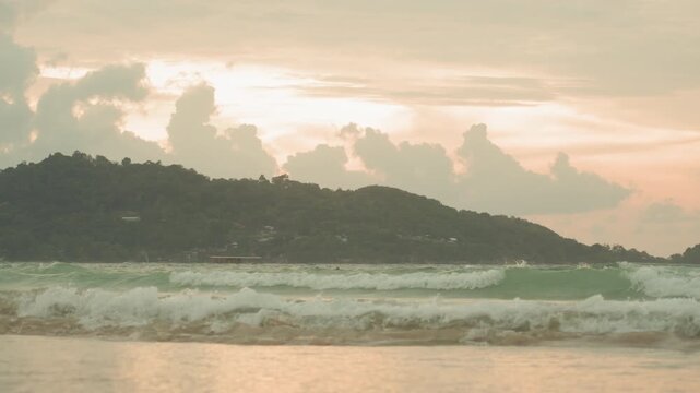 Island silhouette pastel sky waves breaking wide panoramic view with rolling surf, cloud formations, reflective foreground water, moody dusk colors, coastal ridge outline, cinematic atmosphere,