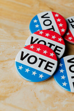cluster of vote badges on a marble surface