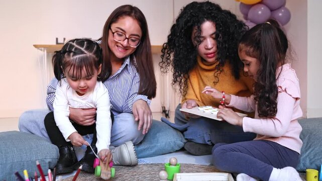 Nursery school teachers playing with two little girls
