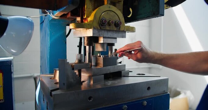Close-up of industrial stamping operation producing metal parts. Factory process, precision work, and metal fabrication